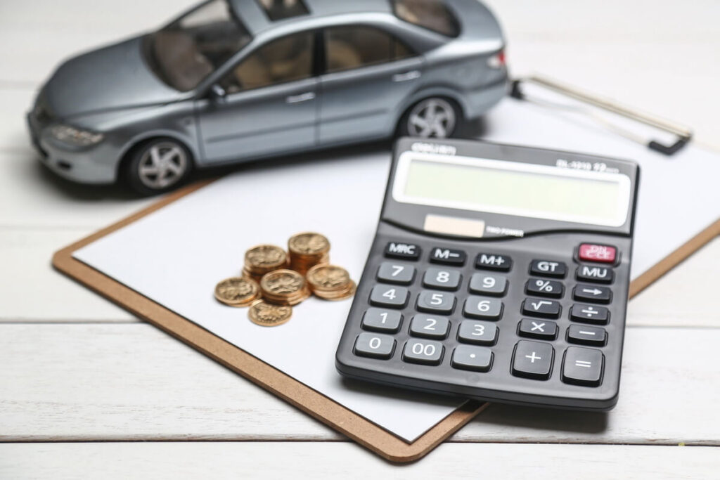 controlar os custos com veículos do CFC: imagem de calculadora, moedas e miniatura de carro